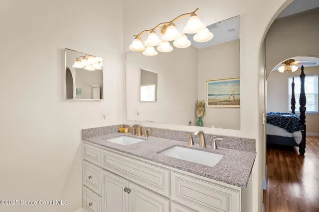 a bathroom with a granite countertop sink a light fixture and a mirror