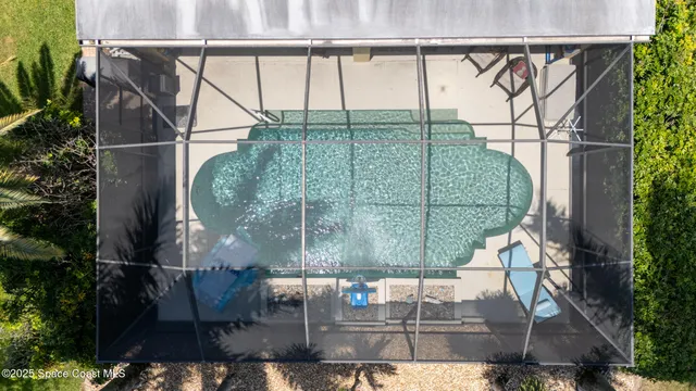 an aerial view of a house with swimming pool and lake view