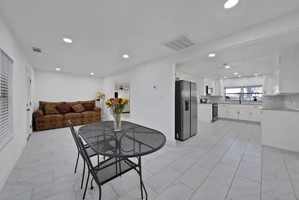 a kitchen with stainless steel appliances kitchen island granite countertop a refrigerator and a stove top oven