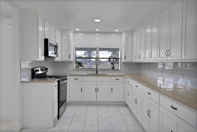 a spacious bedroom with a bed and a chandelier