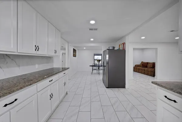 a kitchen with refrigerator and cabinets