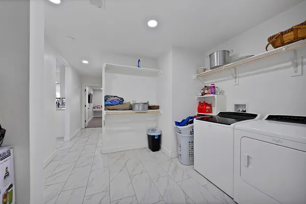 a room with a refrigerator and white cabinets