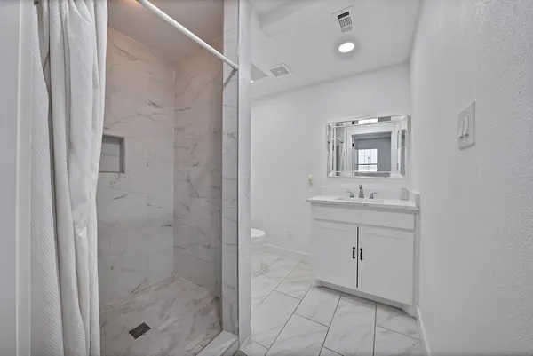 a bathroom with a shower sink and mirror