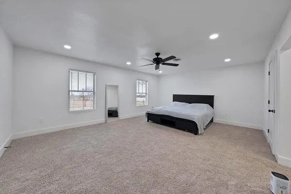 a spacious bedroom with a bed and a chandelier