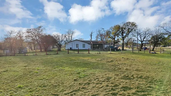 a view of a green field with wooden fence
