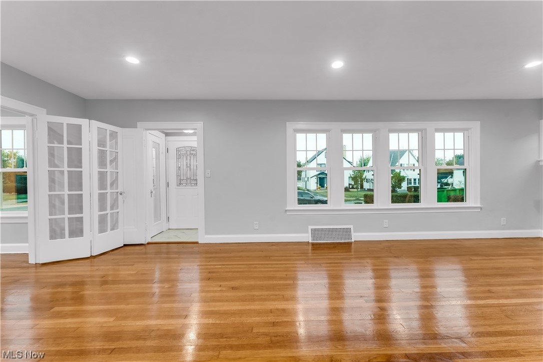 Spare room with a wealth of natural light and light hardwood flooring