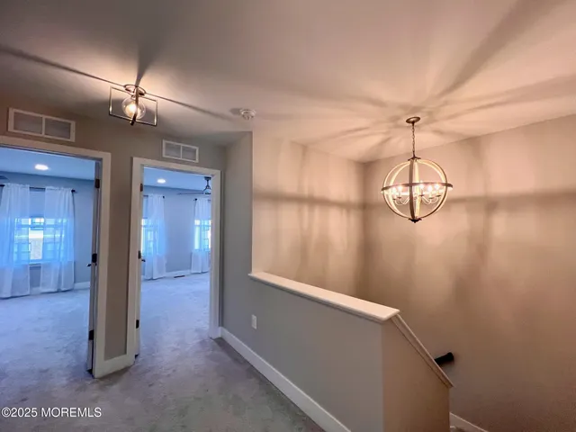 a view of a hallway with chandelier and entryway