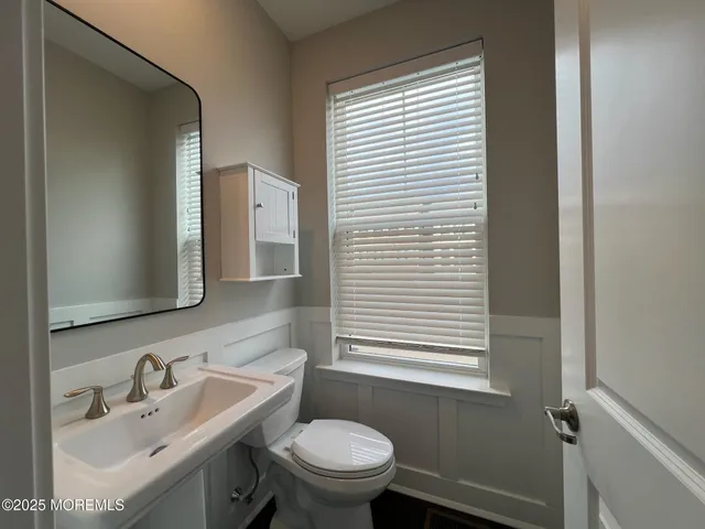 a bathroom with a sink a toilet and a mirror