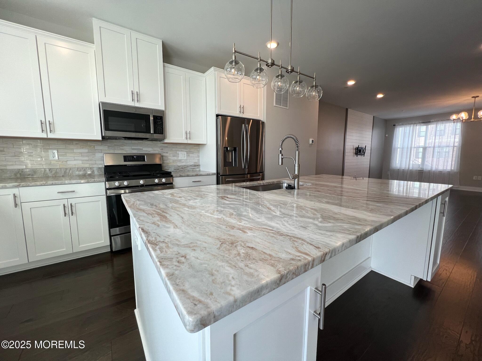32 Mariveles Way Tinton Falls, NJ 07724 - Photo 3 of 28 a kitchen with kitchen island granite countertop wooden cabinets and a refrigerator