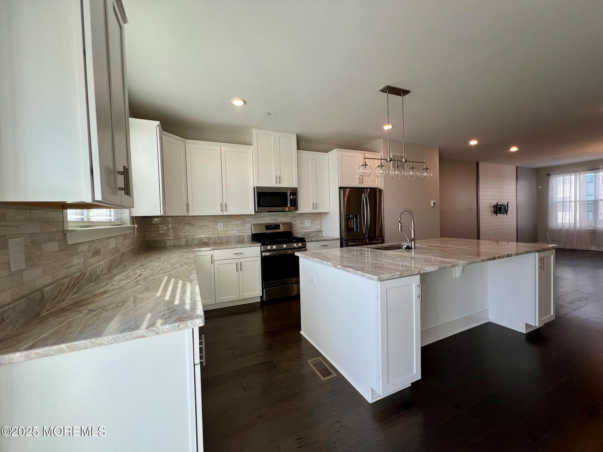 32 Mariveles Way Tinton Falls, NJ 07724 - Photo 4 of 28 a kitchen with stainless steel appliances kitchen island granite countertop a stove a sink and a refrigerator