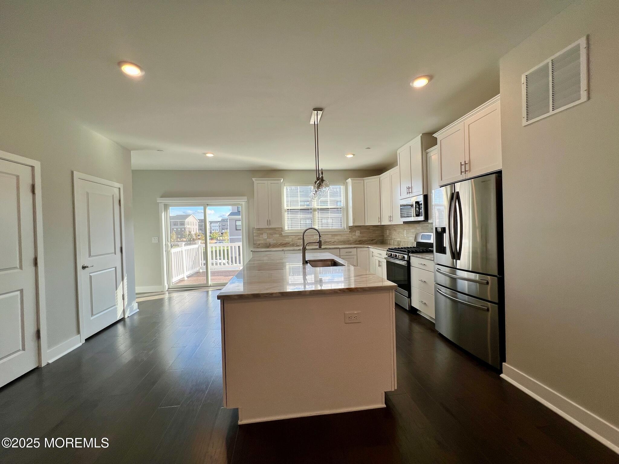 32 Mariveles Way Tinton Falls, NJ 07724 - Photo 9 of 28 a kitchen with stainless steel appliances granite countertop a refrigerator a sink dishwasher a stove and white countertops with wooden floor