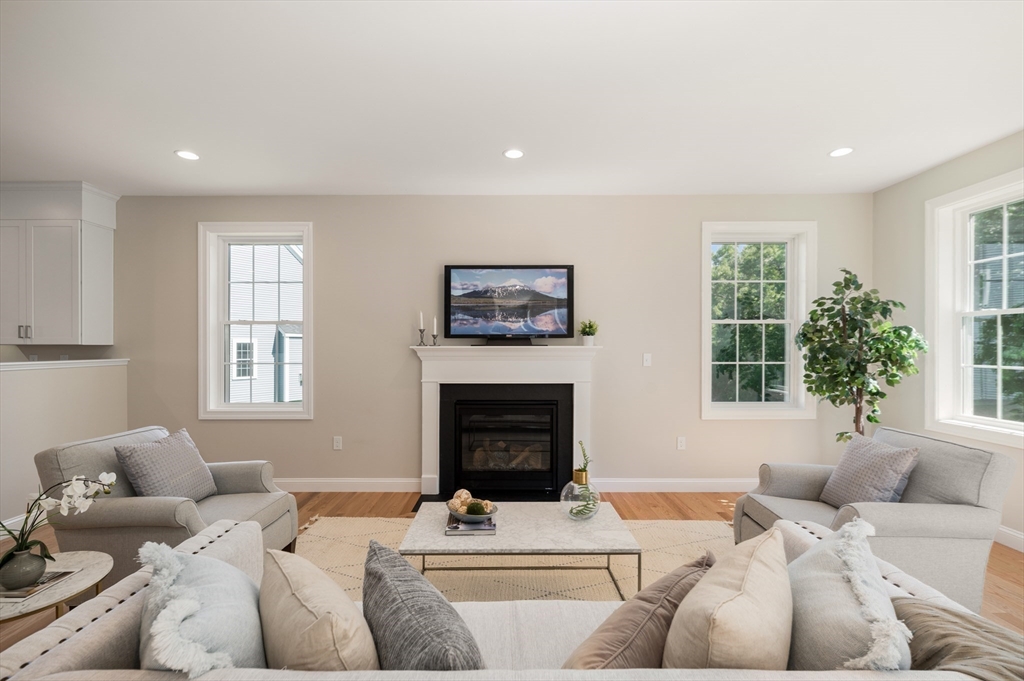 62 High Street, Unit LOT 1 Stoneham, MA 02180 - Photo 11 of 22 a living room with furniture a window and a fireplace