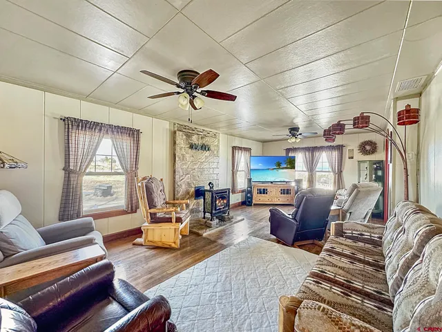 a living room with furniture a flat screen tv and a table