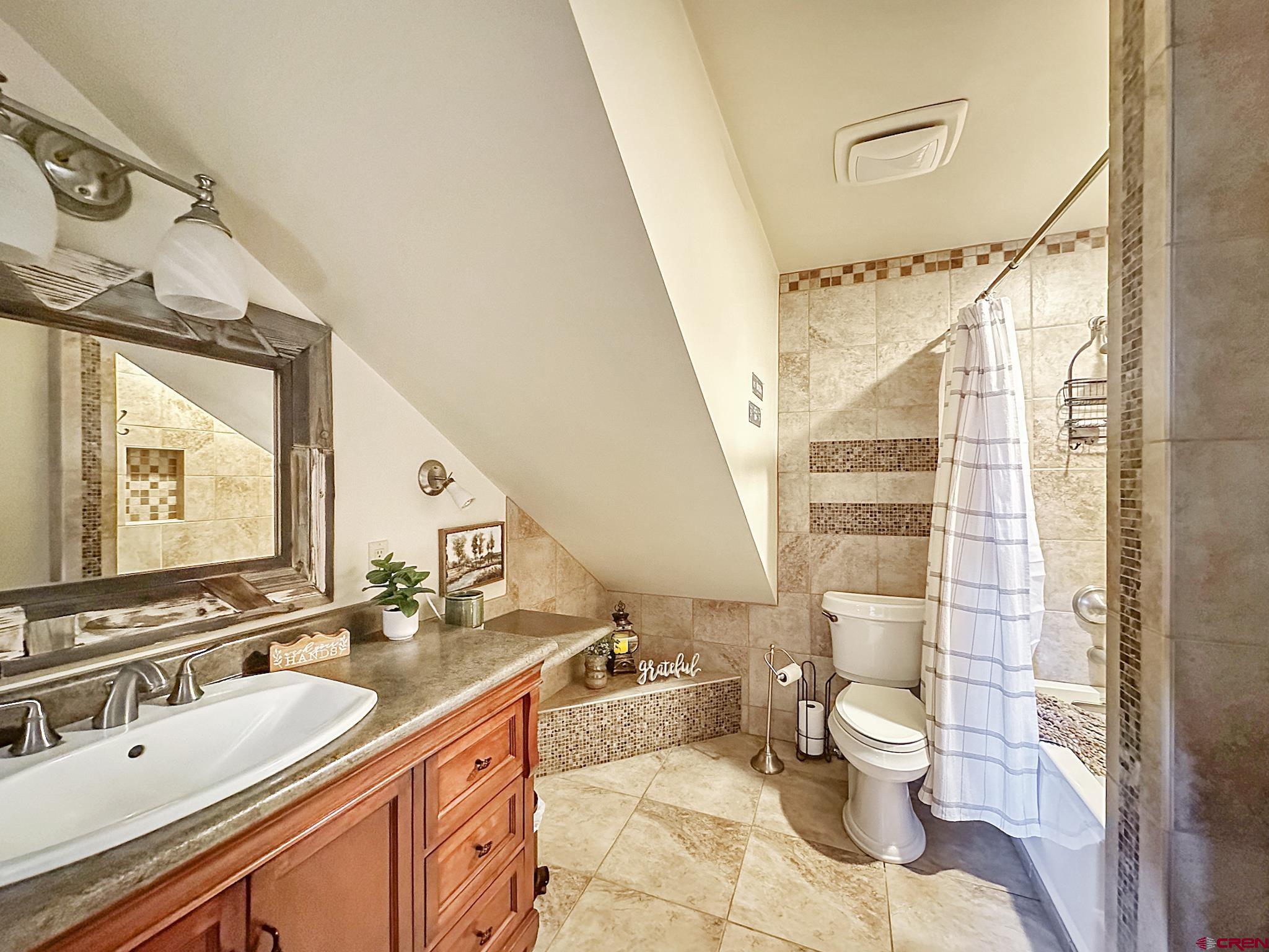 36024 Fruitland Mesa Road Crawford, CO 81415 - Photo 22 of 37 a bathroom with a granite countertop sink mirror vanity and toilet