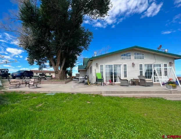 a view of a house with a small yard and wooden fence