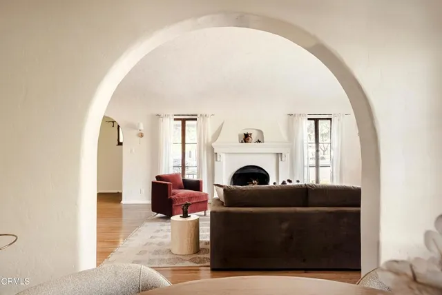 a living room with furniture a fireplace and a large window