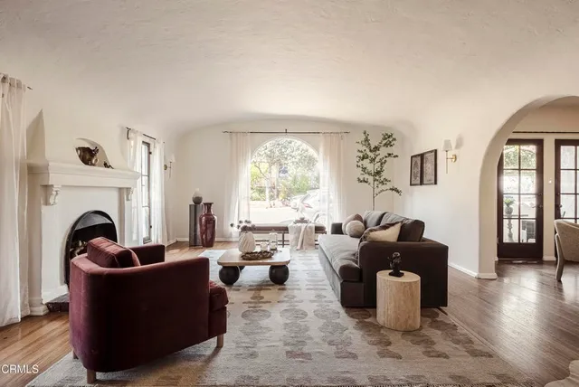 a living room with furniture a fireplace and a large window