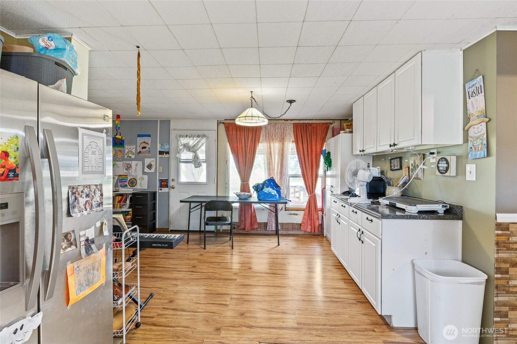 10575 H 8 Moses Lake, WA 98837 - Photo 7 of 9 a kitchen with stainless steel appliances granite countertop a refrigerator a sink dishwasher a dining table and chairs with wooden floor