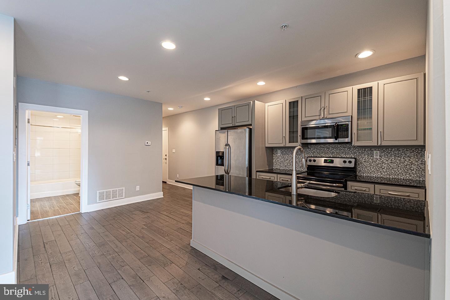 135 North 3rd Street, Unit 3D Philadelphia, PA 19106 - Photo 5 of 20 a kitchen with stainless steel appliances a refrigerator and a stove top oven