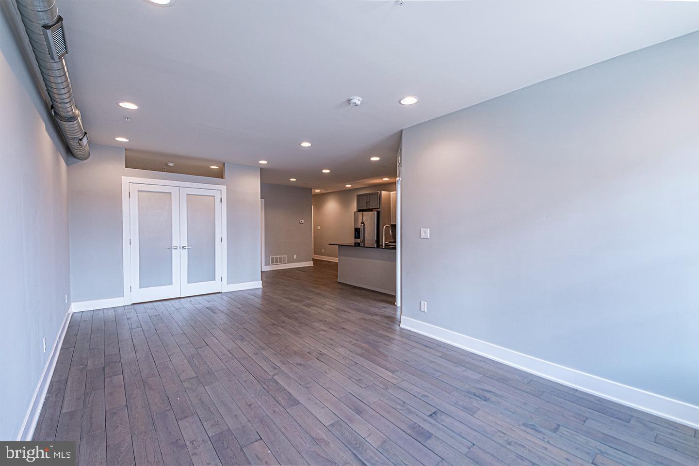 135 North 3rd Street, Unit 3D Philadelphia, PA 19106 - Photo 8 of 20 a view of a big room with wooden floor and a kitchen