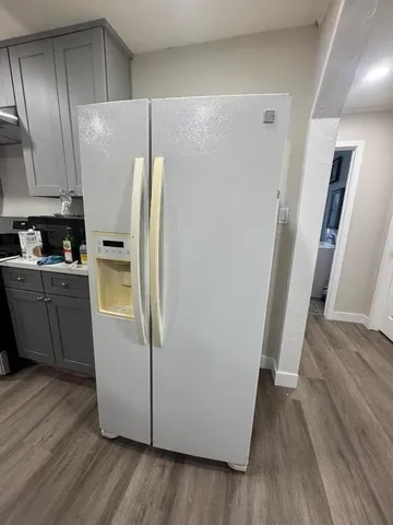 a kitchen with stainless steel appliances a refrigerator and wooden floor