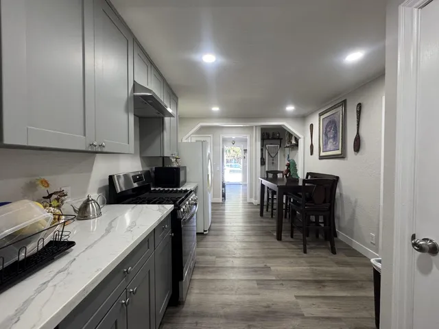 a kitchen with granite countertop cabinets a dining table and chairs with wooden floor