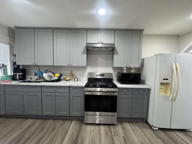 a kitchen with a white stove top oven and refrigerator