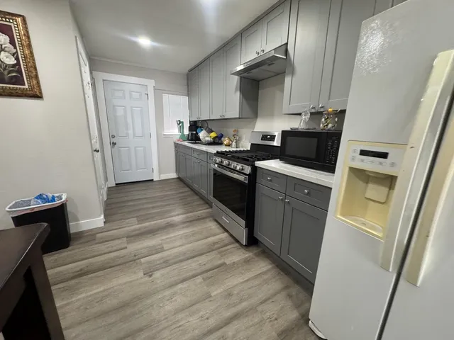 a kitchen with sink a refrigerator and cabinets