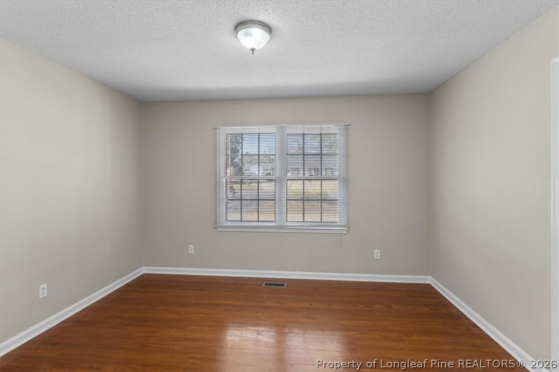 630 Bedford Road Fayetteville, NC 28303 - Photo 6 of 21 an empty room with wooden floor and windows