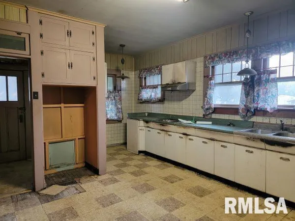 a kitchen with granite countertop a refrigerator a sink and a stove