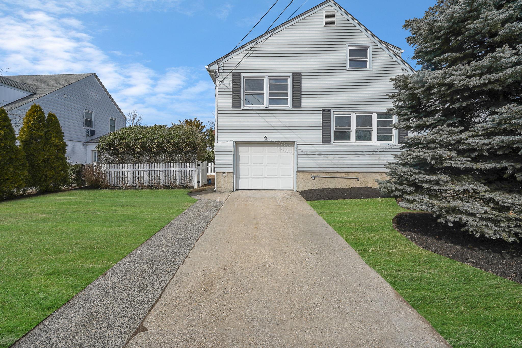 163 Wright Avenue Malverne, NY 11565 - Photo 1 of 1 a front view of a house with a yard and garage