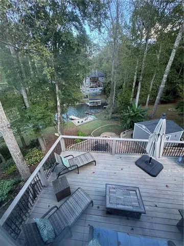 a view of roof deck with chairs and wooden fence