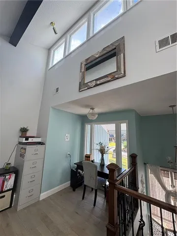 a view of a hallway with wooden floor and furniture