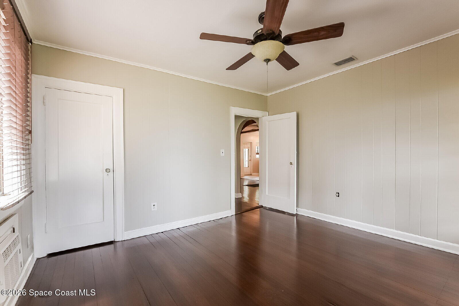 1428 Riverside Drive Titusville, FL 32780 - Photo 7 of 17 an empty room with wooden floor chandelier fan and windows