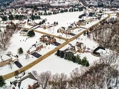 an aerial view of a house with a lake