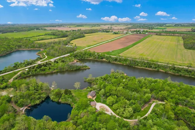 an aerial view of residential houses with outdoor space and lake view