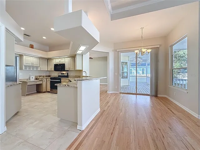 a large kitchen with cabinets wooden floor and stainless steel appliances
