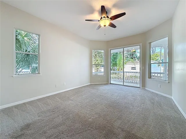 a view of a big room with windows and chandelier fan