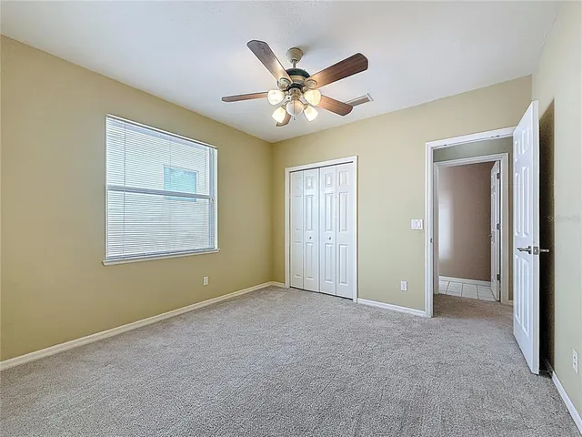 a view of an empty room with a ceiling fan and a window