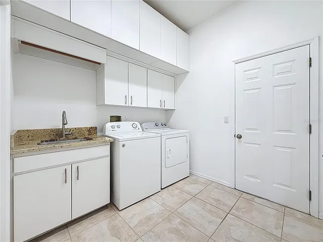 a utility room with cabinets washer and dryer