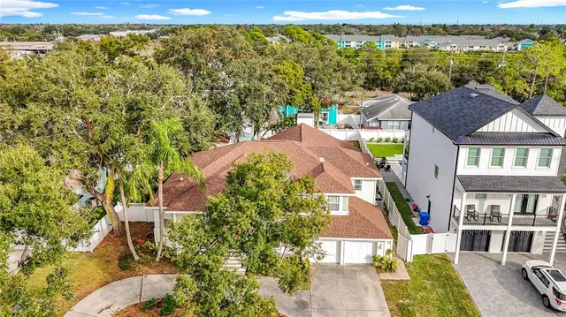 an aerial view of residential houses with outdoor space and trees
