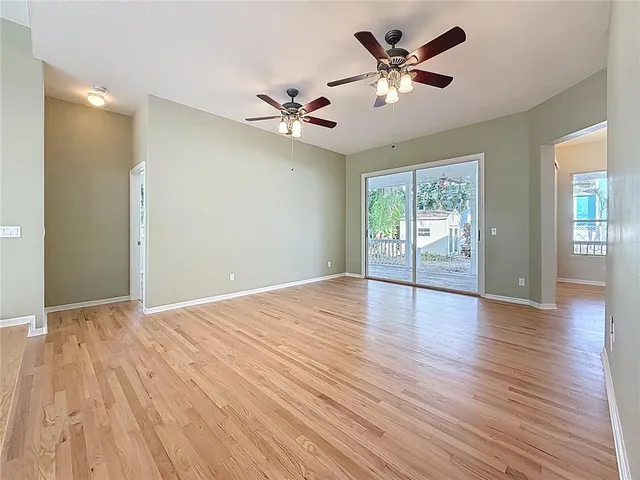 a view of an empty room with window and wooden floor