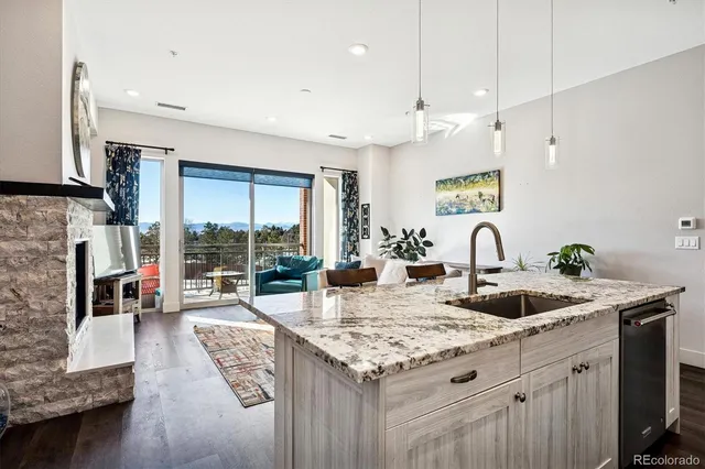 a kitchen with granite countertop a sink a counter top space and living room view
