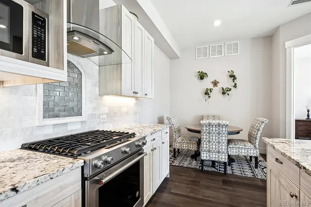 a kitchen with a stove and wooden floor