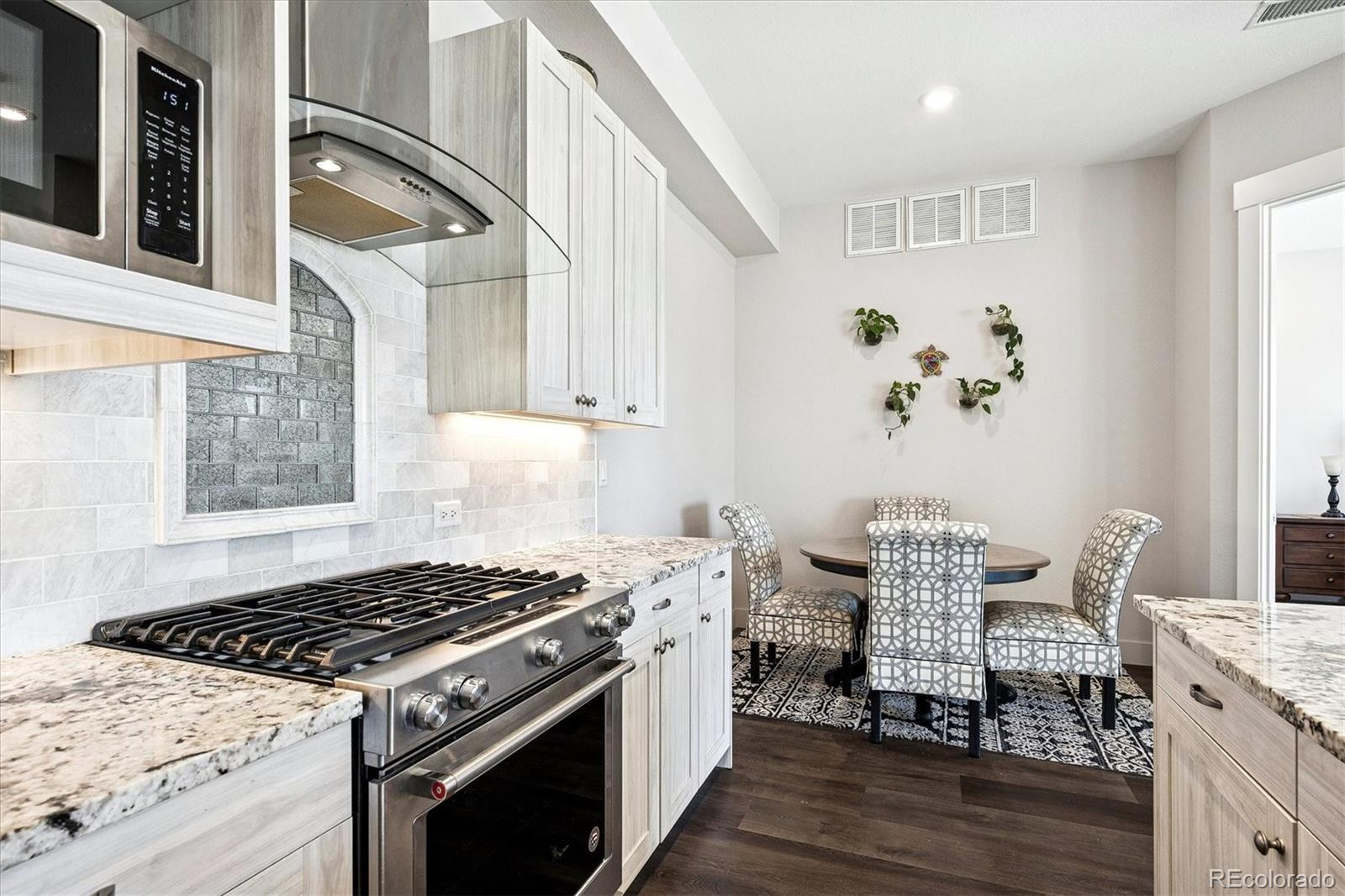 4885 South Monaco Street, Unit 207 Denver, CO 80237 - Photo 19 of 33 a kitchen with a stove and wooden floor