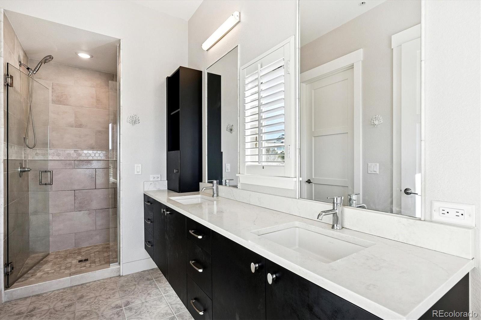 4885 South Monaco Street, Unit 207 Denver, CO 80237 - Photo 23 of 33 a bathroom with a double vanity sink mirror and shower