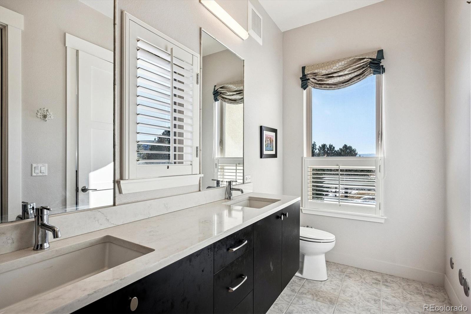 4885 South Monaco Street, Unit 207 Denver, CO 80237 - Photo 24 of 33 a bathroom with a sink a toilet a mirror and a window