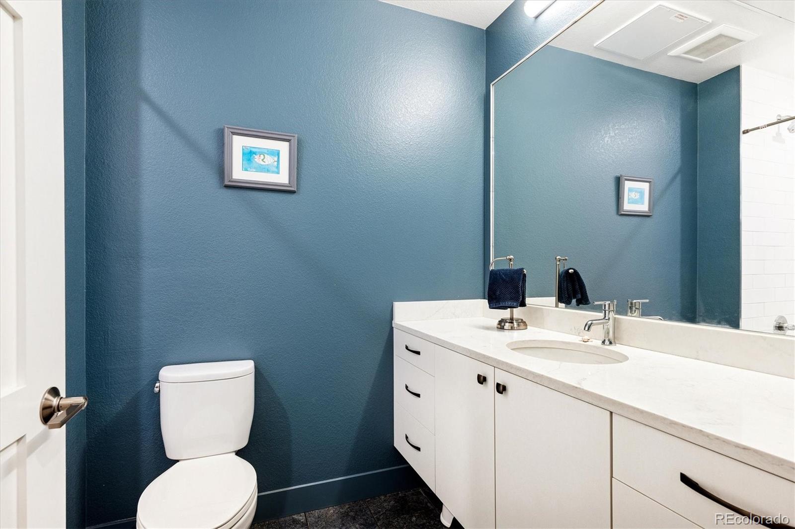 4885 South Monaco Street, Unit 207 Denver, CO 80237 - Photo 27 of 33 a bathroom with a toilet sink and mirror