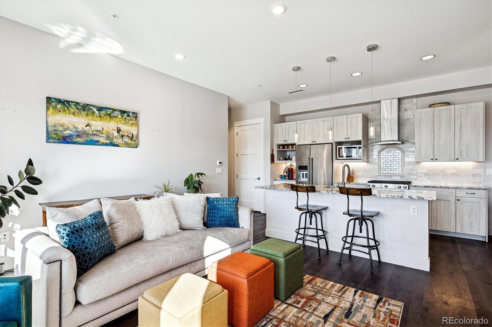 4885 South Monaco Street, Unit 207 Denver, CO 80237 - Photo 6 of 33 a living room with furniture kitchen view and a wooden floor