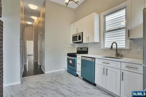 a kitchen with white cabinets and appliances